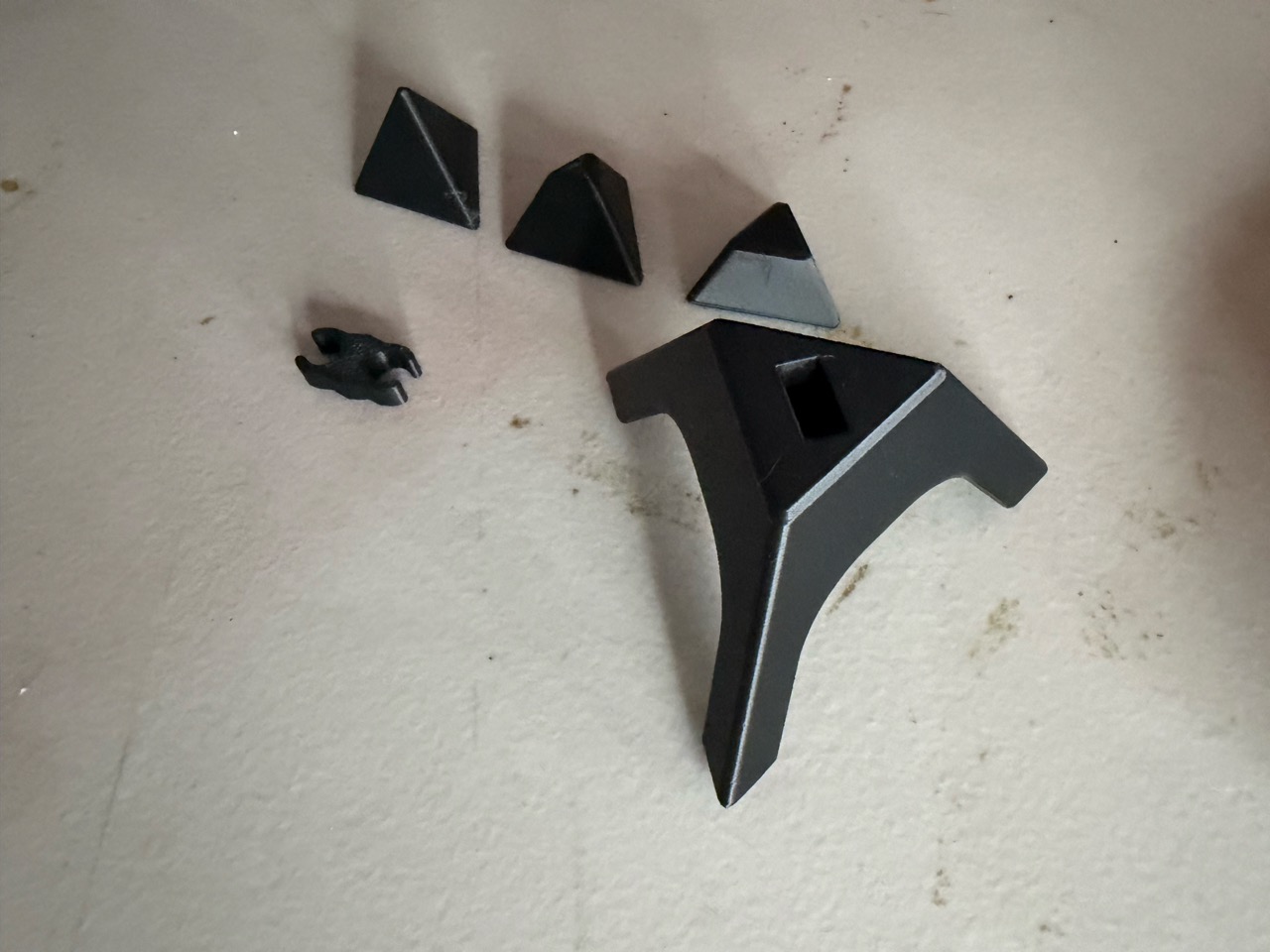 The printed parts separated: interchangeable tips, base, and central block